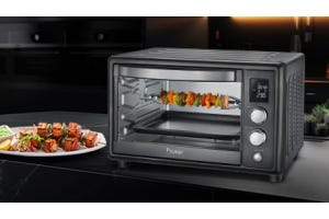 Prestige OTG oven grilling vegetables and meats with a plate of grilled food on a modern kitchen countertop.