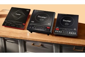 Three Prestige induction cooktops placed on a wooden countertop