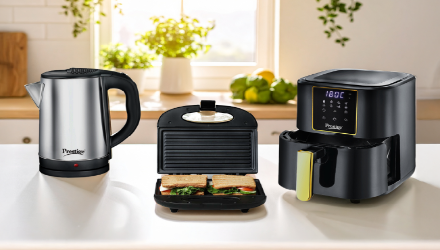 Prestige electric kettle, sandwich toaster, and air fryer placed on a kitchen countertop with fresh greenery in the background.