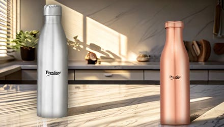 A silver stainless steel bottle and a copper bottle from Prestige placed on a kitchen counter