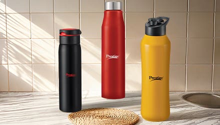 Three Prestige brand water bottles in black, red, and yellow colors, placed on a kitchen counter