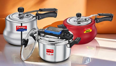 Three Prestige pressure cookers in silver, red, and white colors, displayed on a kitchen counter.