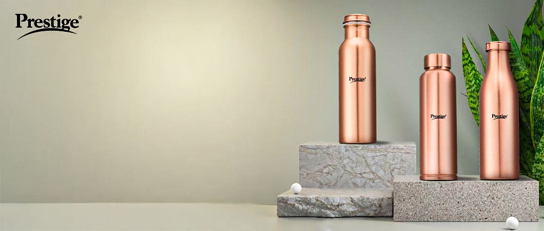 Prestige copper water bottles displayed on stone platforms with a minimalist background