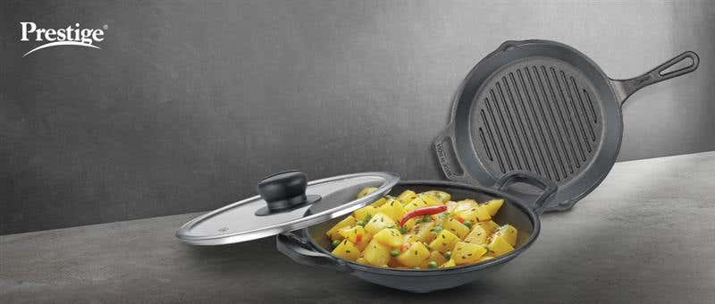 Prestige cast iron cookware featuring a skillet with lid and grill pan, displaying cooked vegetables, showcasing the versatility of cast iron cookware.