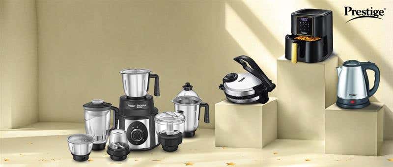 Prestige kitchen appliances including a mixer grinder, air fryer, electric kettle, and more, displayed on pedestals in a modern setting showcasing essential kitchen gadgets.