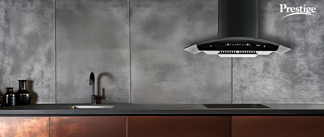 Prestige black kitchen chimney installed in a modern kitchen with dark grey walls and brown cabinets, enhancing ventilation and smoke-free cooking.